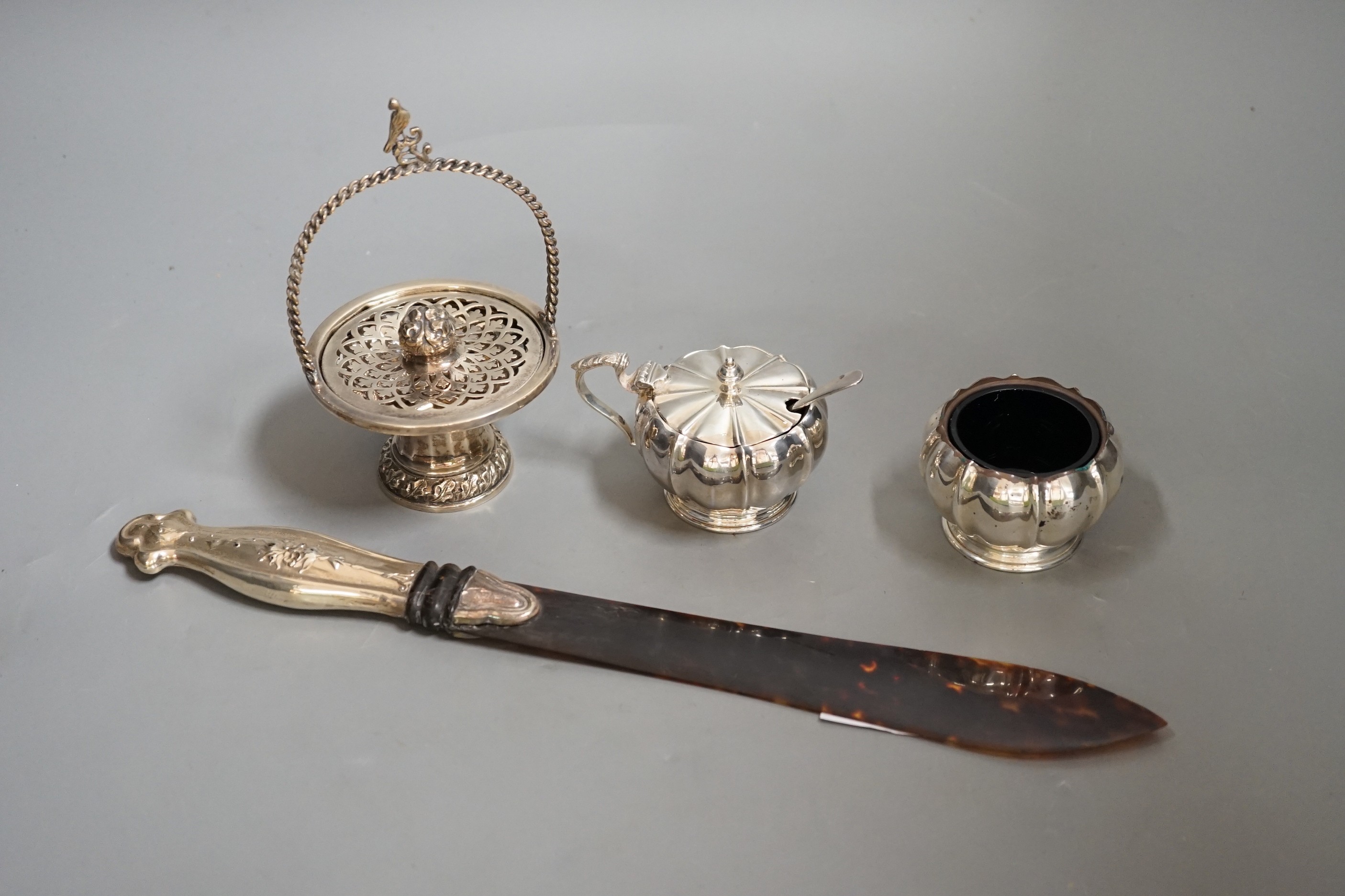 A white metal handled tortoiseshell paper knife and sundry small silver items, including an Edwardian pot pourri basket and two silver condiments by Elkington & Co.